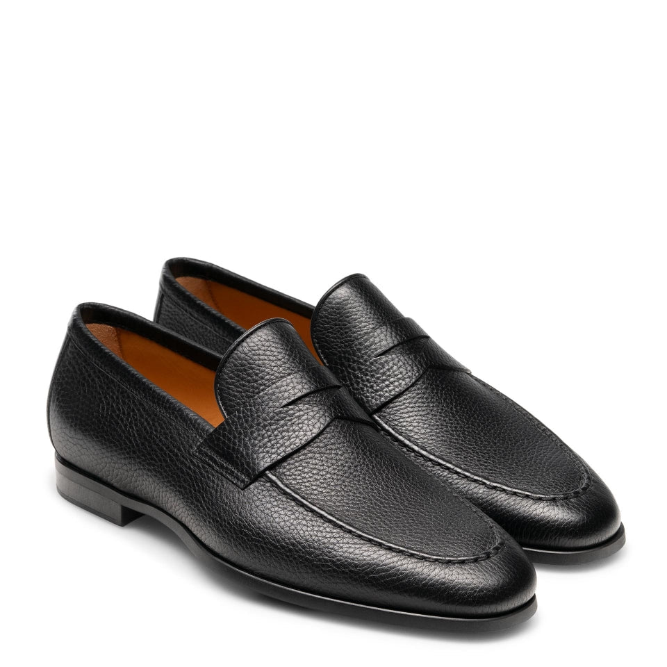 Pair of black leather loafers on a white background