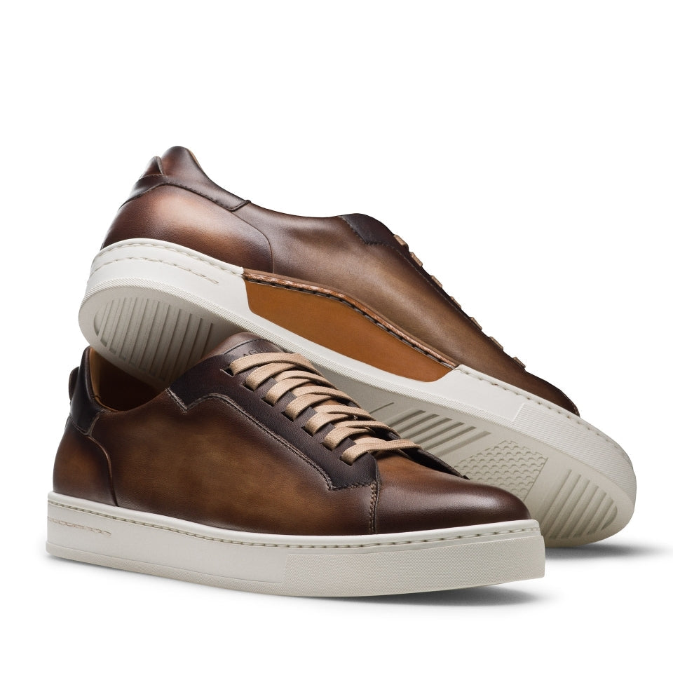 Pair of brown sneakers with white soles on a white background