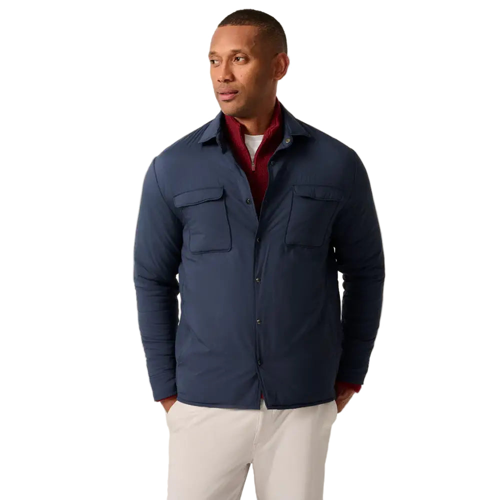 Man wearing a navy jacket with a plain background