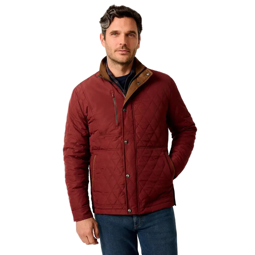 Man wearing a red quilted jacket with a beige collar against a plain background