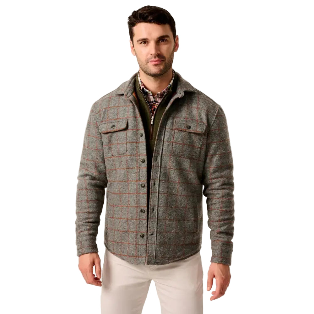 Man wearing a gray checkered jacket on a plain background