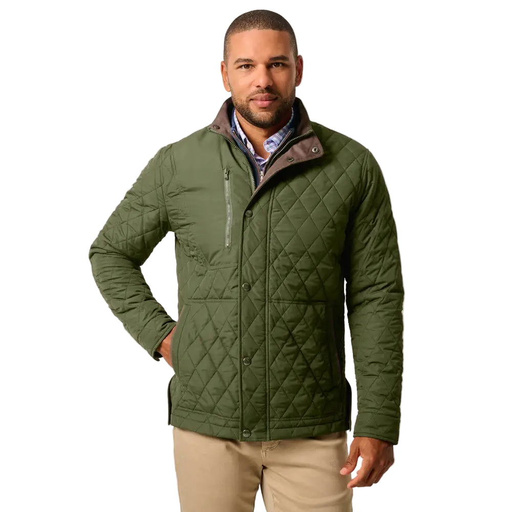 Man wearing a green quilted jacket on a plain background